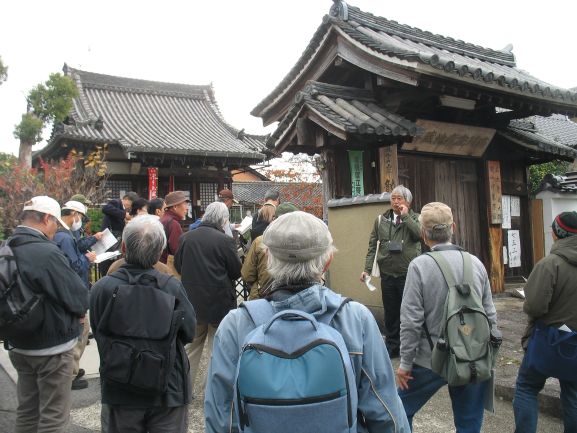 寺の前で深澤が訪問地の解説